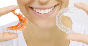 Aparat ortodontyczny – co jest trendy? hands holding retainer for teeth and tooth tray